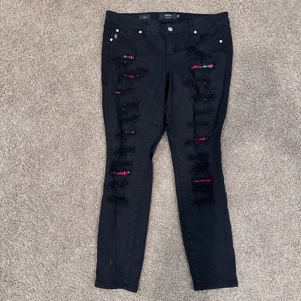 Black skinny jeans with plaid behind holes
